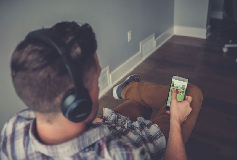 A young man listening to an audiobook to learn English online