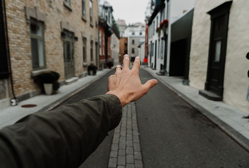 An outstretched hand reaching down the road