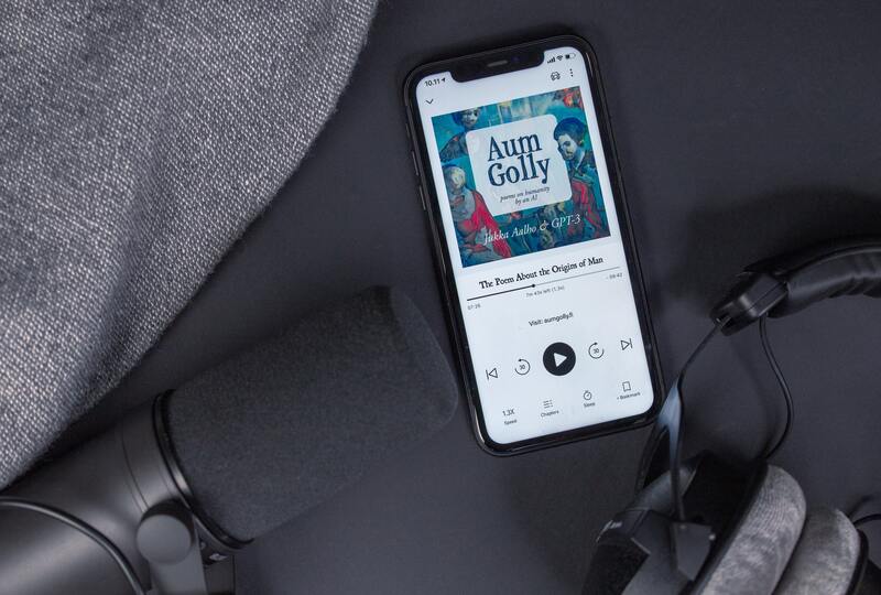 Audiobook on black iphone next to microphone