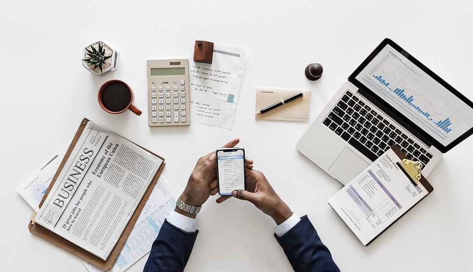 Man at desk with newspaper and phone