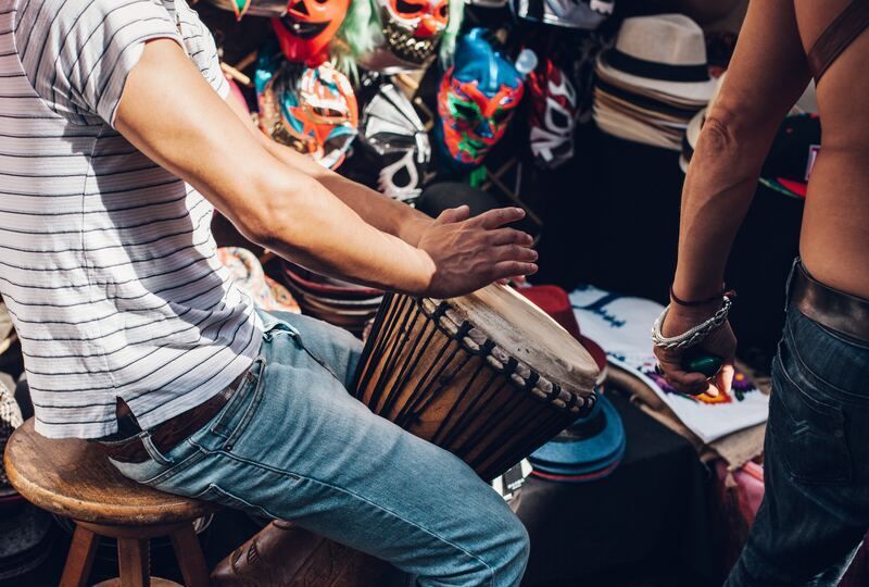 A man playing Latin music on a drum with his hands