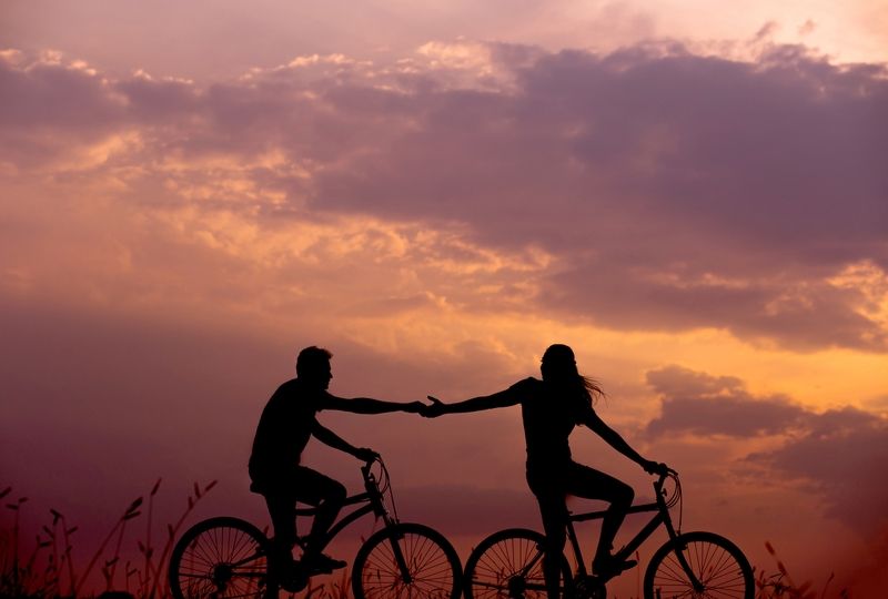 Couple riding bikes during sunset