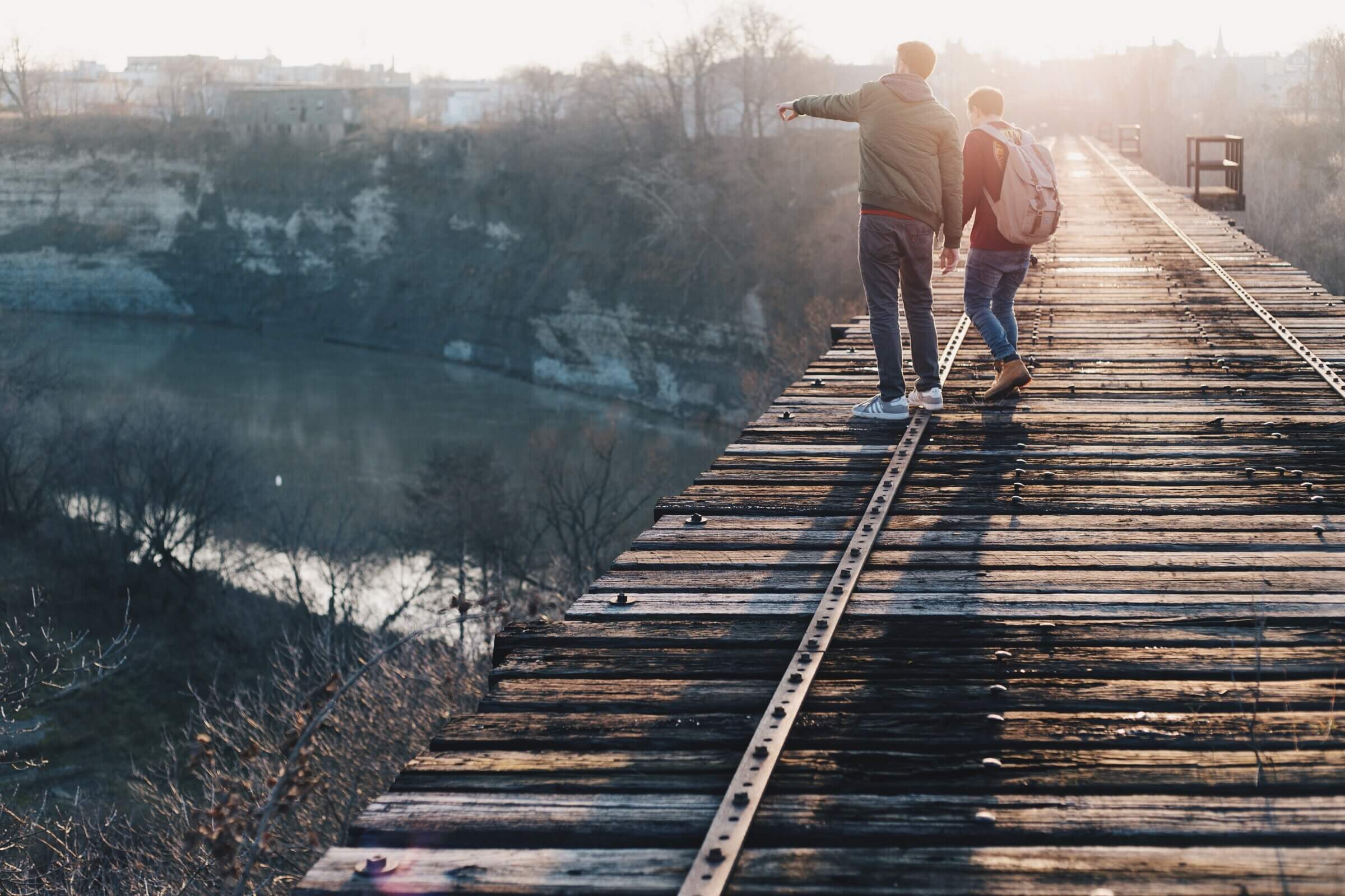 two boys hanging out on a bridge