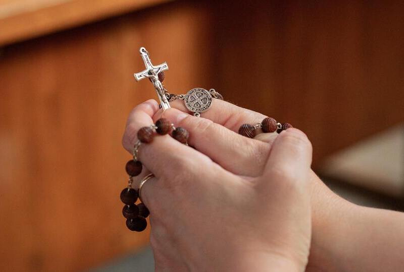 Hands praying with a rosary