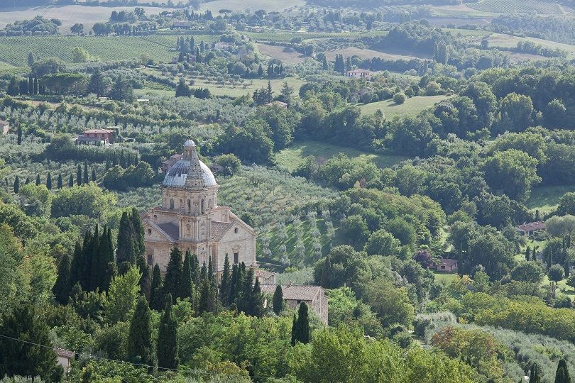 A view of the Italian countryside with a building in the foreground