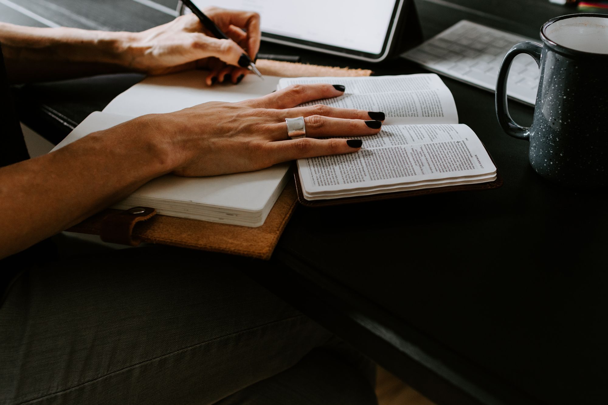 woman reading and journaling at the table