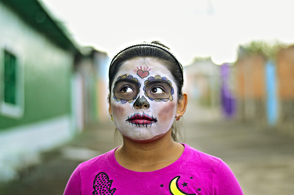 little girl with day of the dead makeup in town