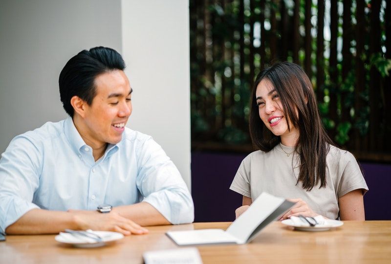 man and woman sitting on chair in front of desk