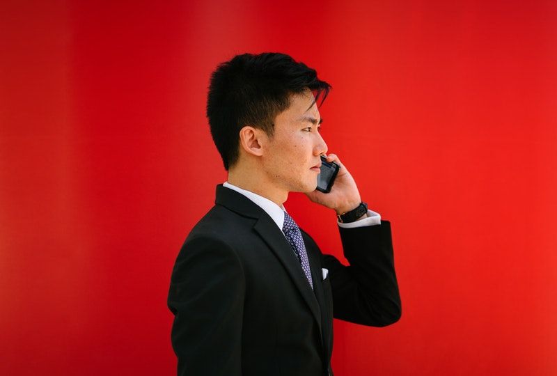 man holding smartphone wearing suit