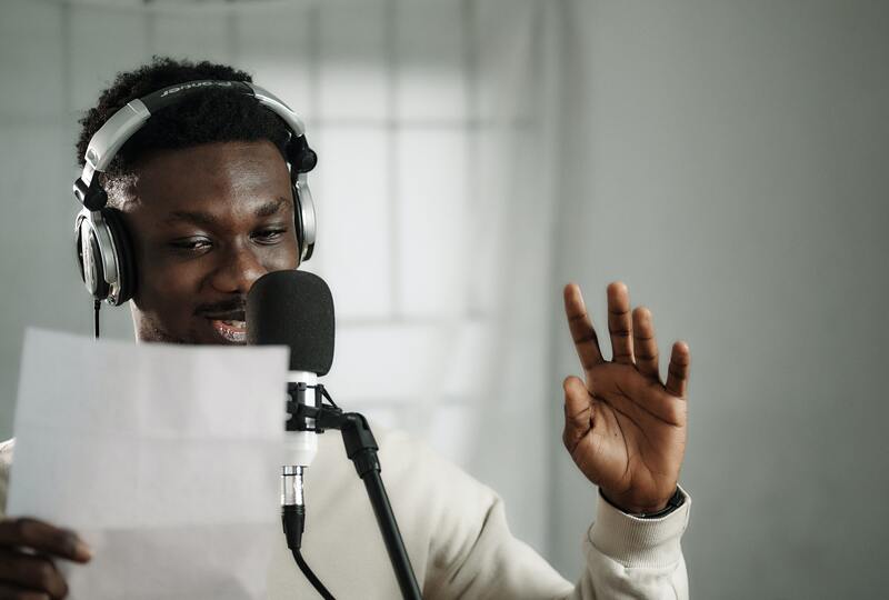 Man speaking into microphone with headphones