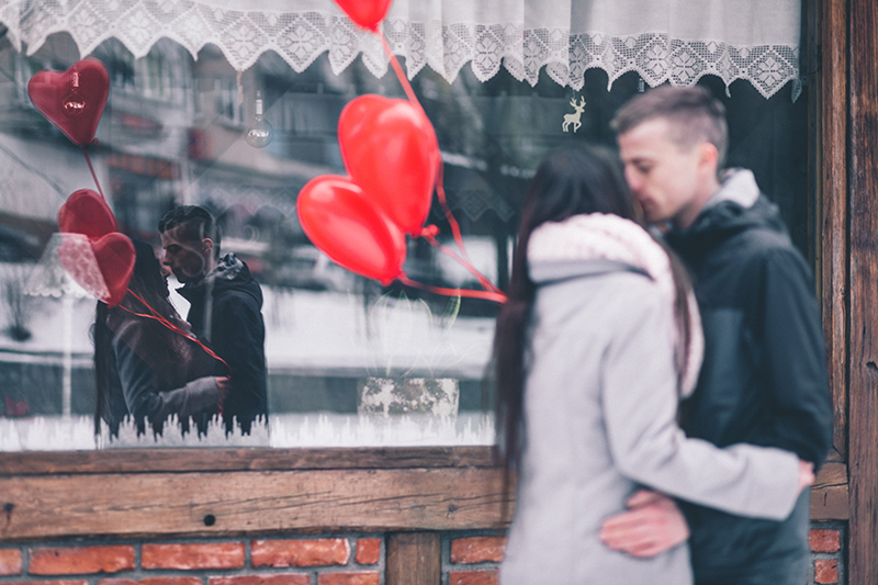 People Kissing on Valentines Day in Front of Shop