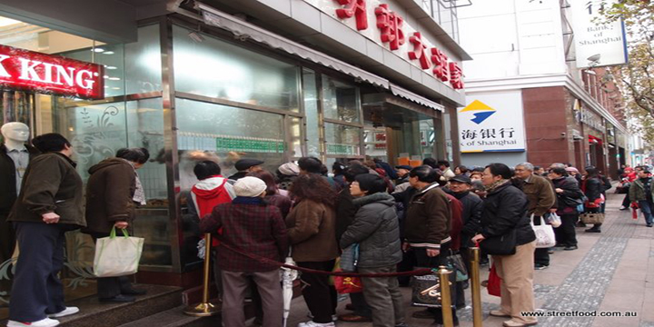 Chinese people queueing for food on a street in Shanghai