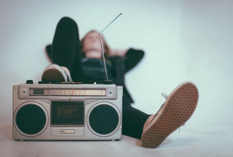 Person lying with foot on radio