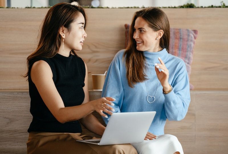 Two women speaking in French over a laptop