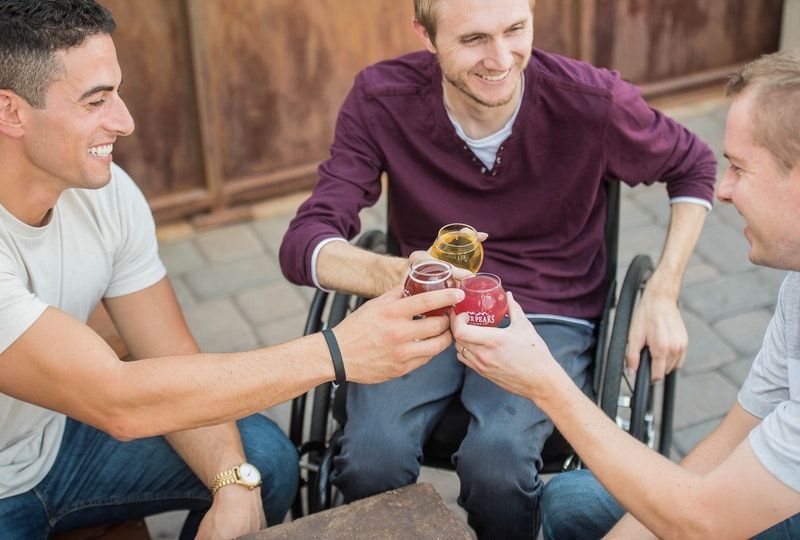 three friends enjoy drinks outside