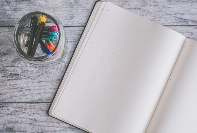 Notebook and pens on table