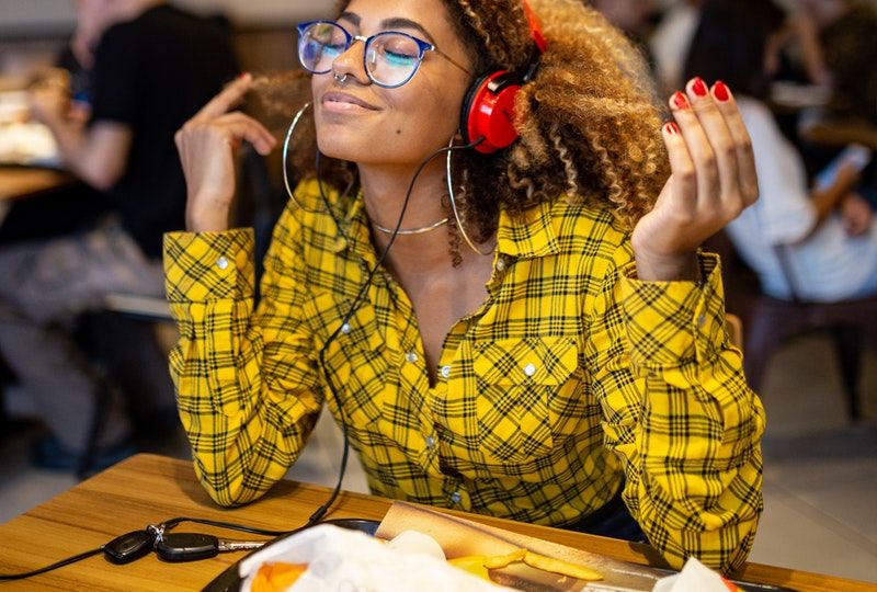 Smiling woman with headphones in cafe