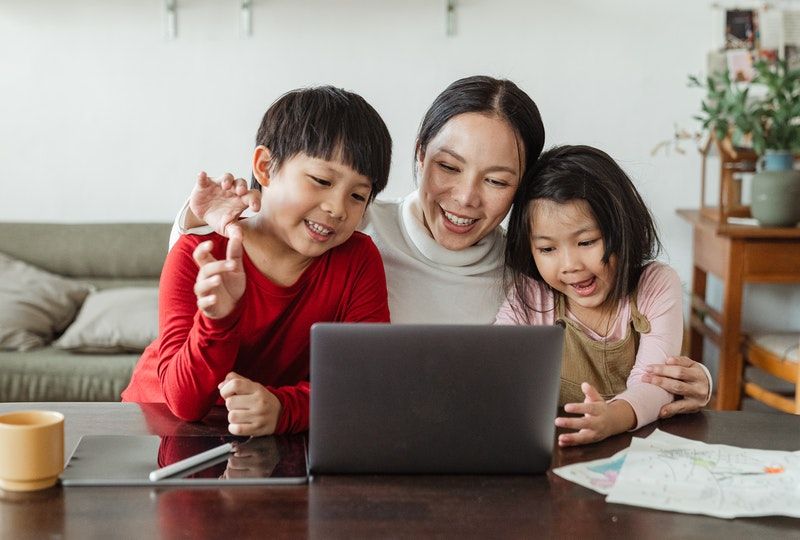 mother and kids look at a screen