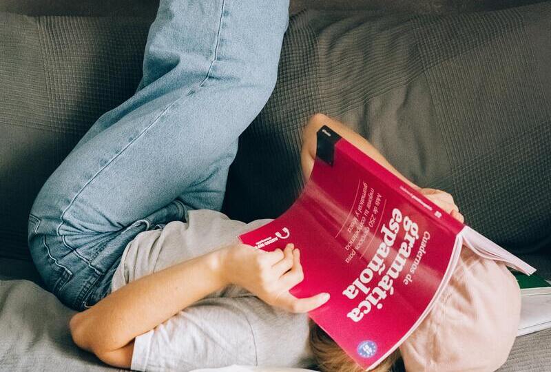 A woman with her head buried in a Spanish grammar book