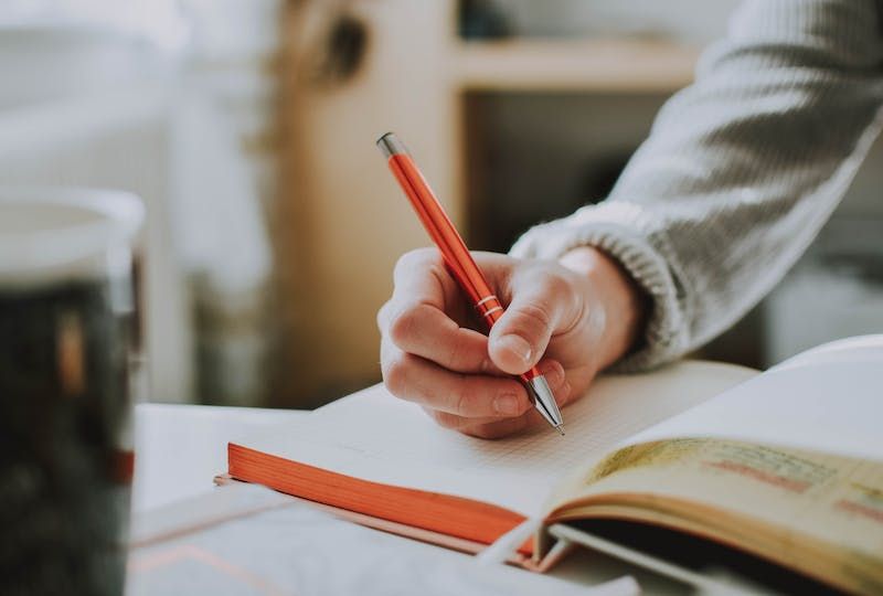 Person writing in a notebook.