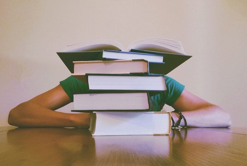 Girl behind a stack of books.