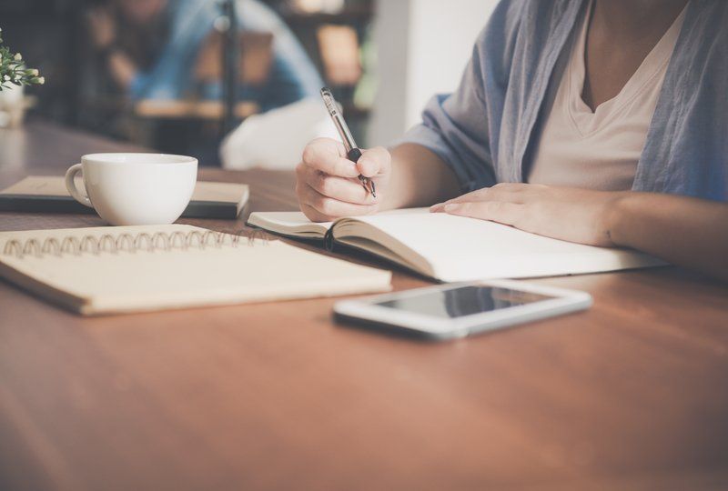 desk space with computer, notepad, and smartphone