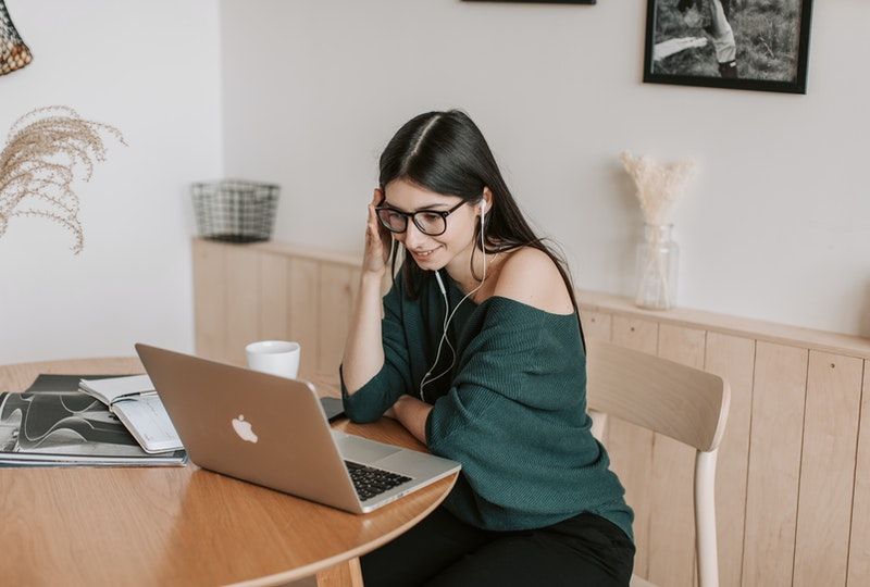 woman using laptop with earphones