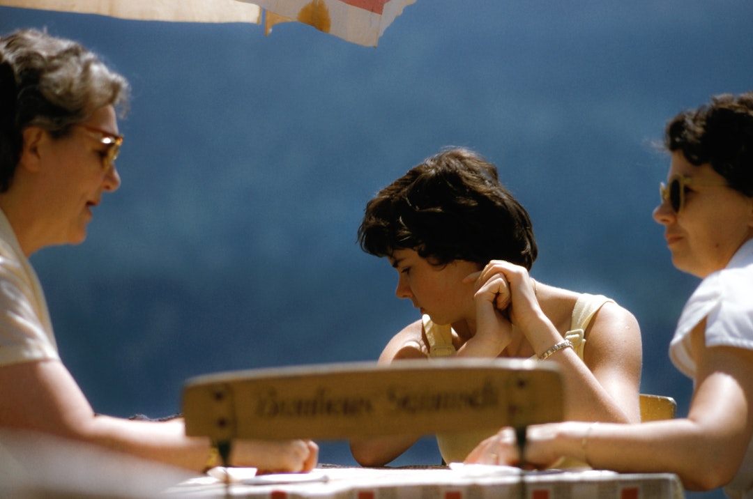 A family conversing at an outdoor restaurant table