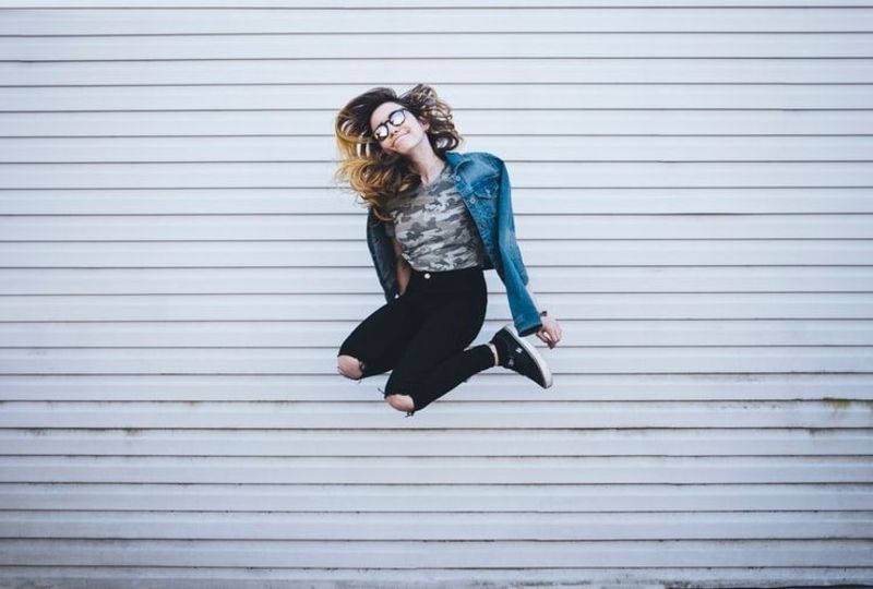 a girl shows positive attitude by jumping