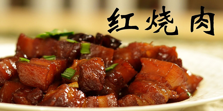 A plate of brasied, red pork chopped into cubes with seasoning