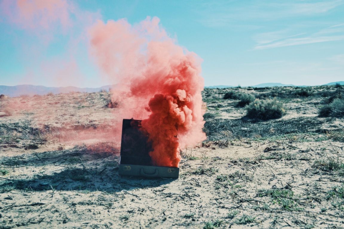 red smoke blowing out of a suitcase