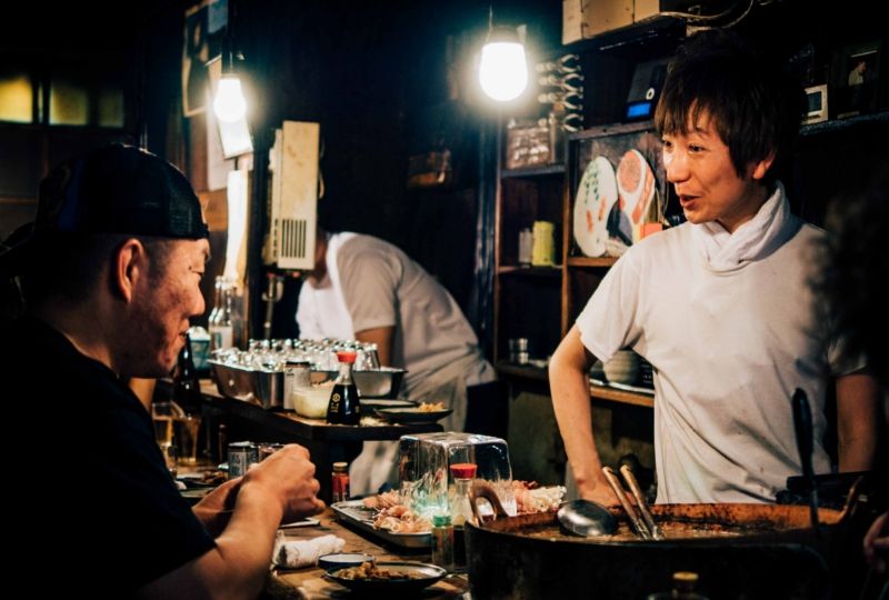 Restaurant owner talking to customer at night