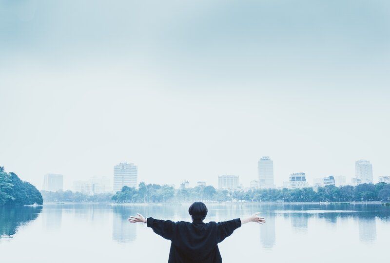 person standing confidently in front of a river