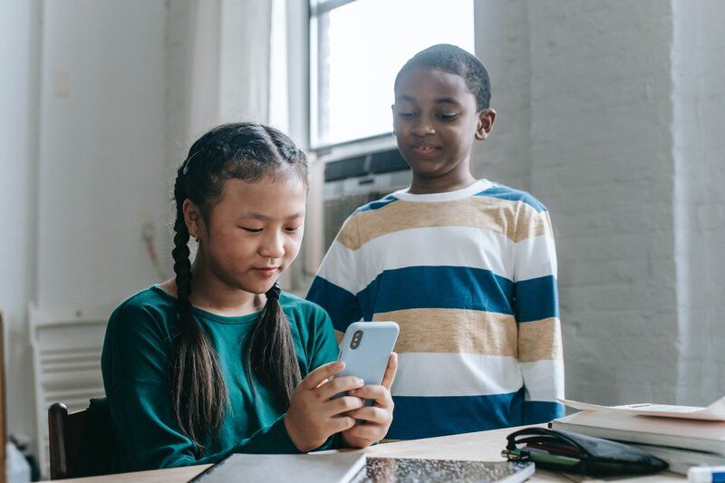 two children texting together