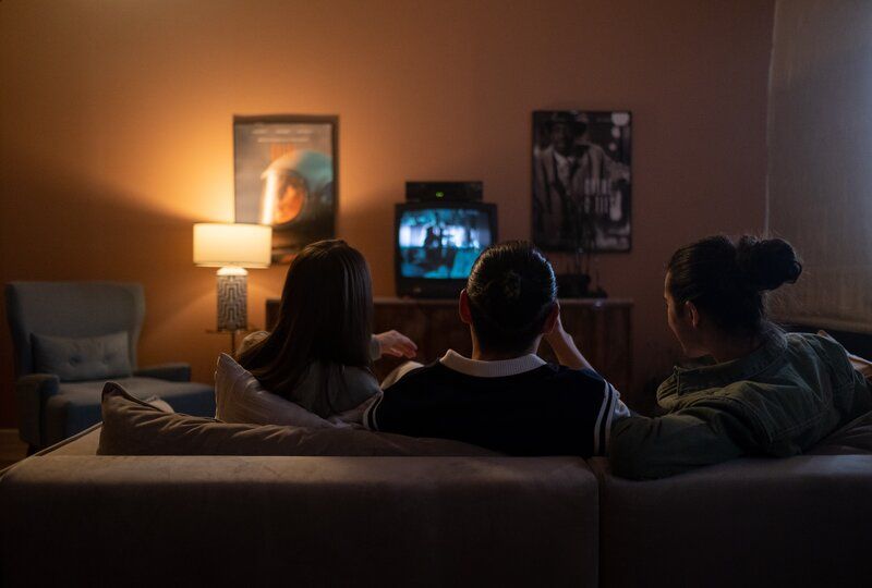 friends sitting on a couch watching a movie