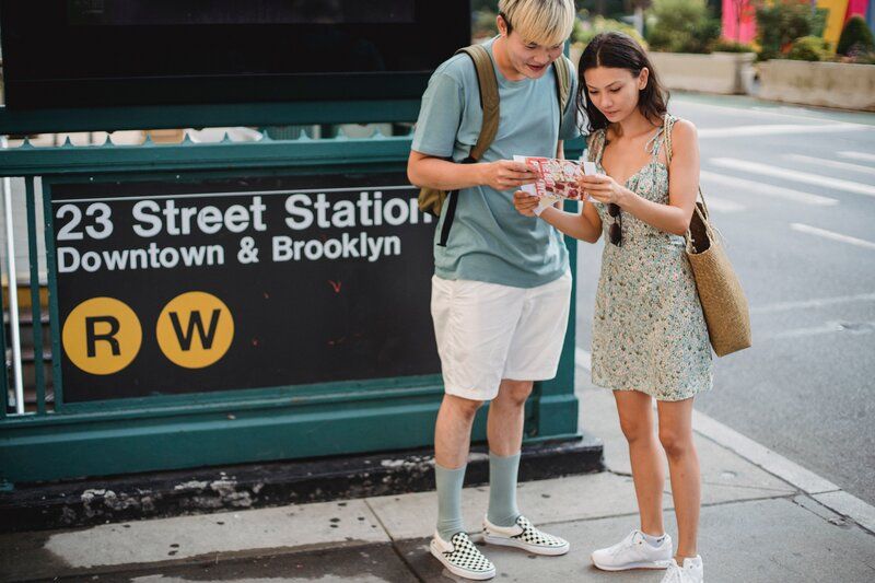 couple looking at a map in front of the subway