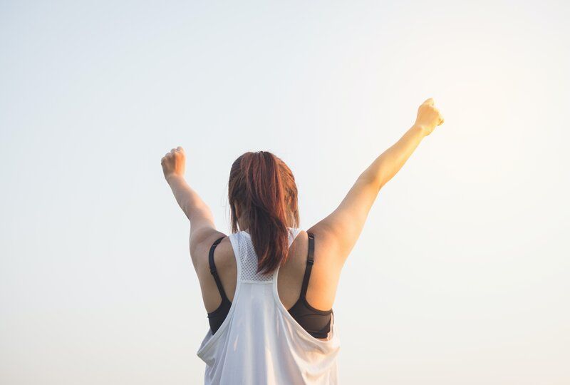 woman raising her hands in the air