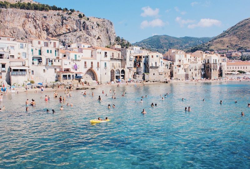 An beach with houses at the waterline in Taorima, Sicily