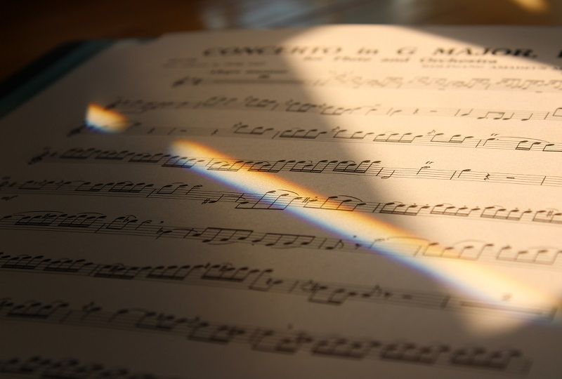 An extreme close up of sheet music in deep shadow