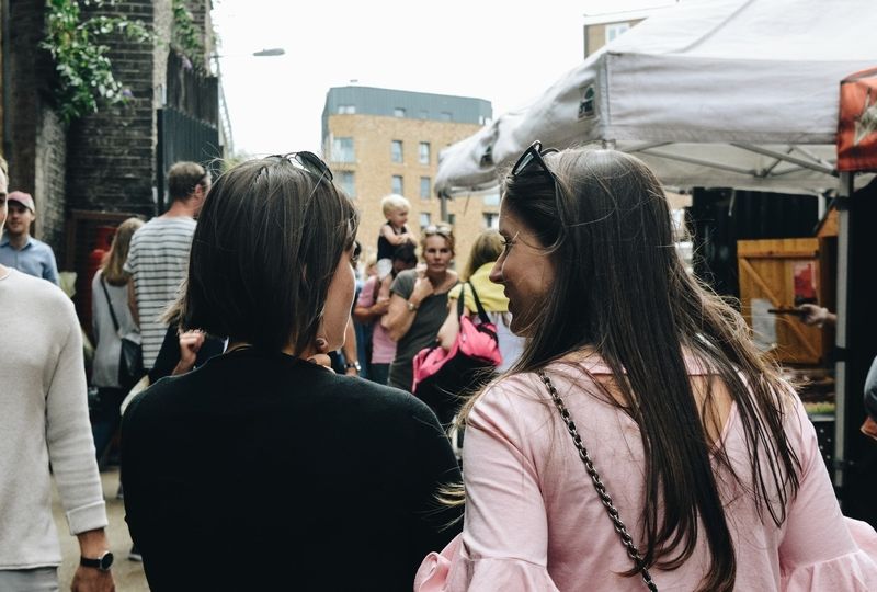 Two women talking on a busy street