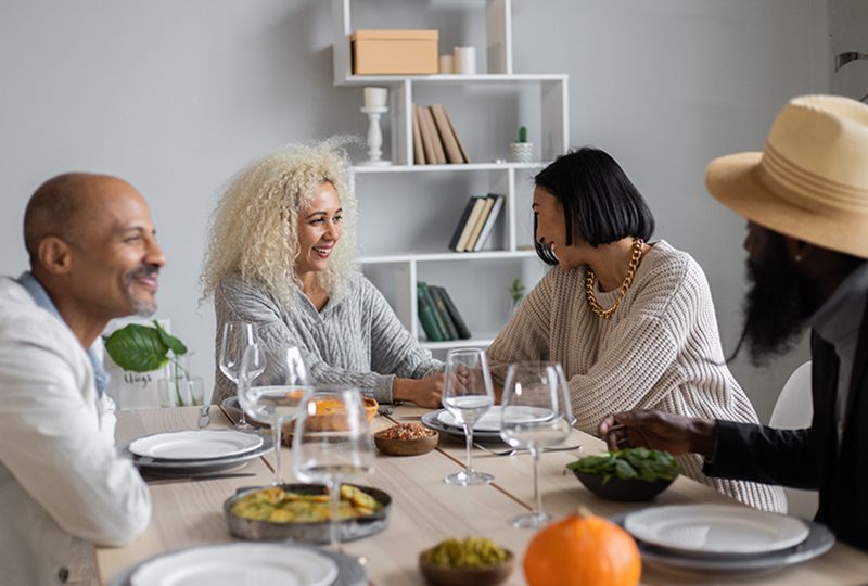 Two men and two women are talking on a table