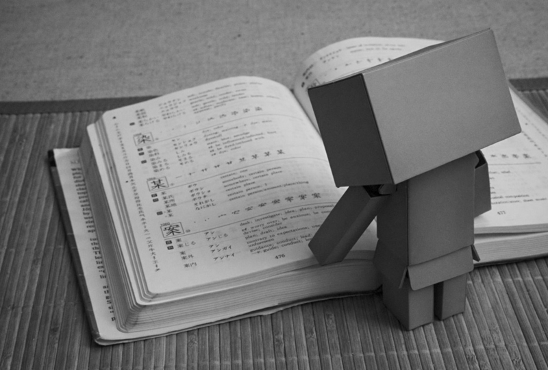 Cardboard robot reading Kodansha Kanji Learner's Course