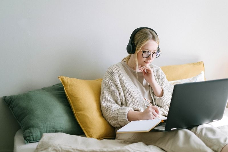 Woman on sofa studying foreign language