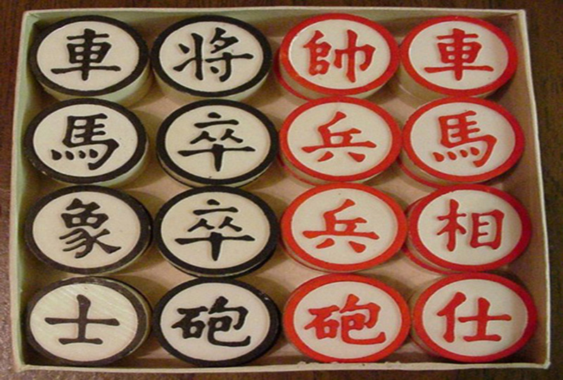 Wooden box containing six red Chinese chess pieces and six black Chinese chess pieces