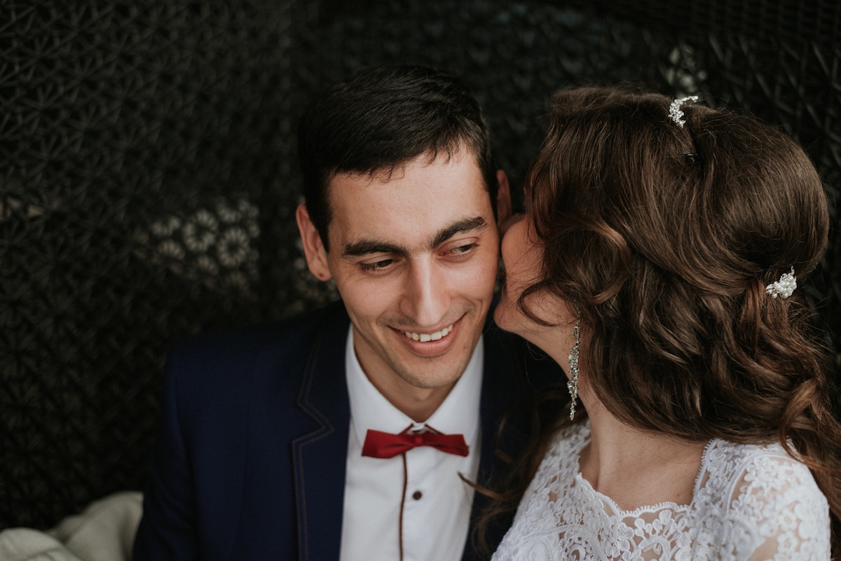 A woman kissing a man on the cheek